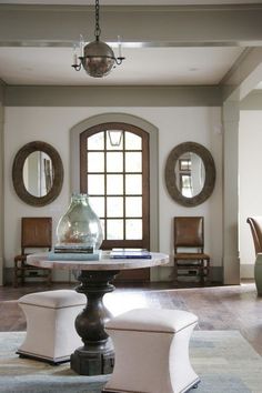 a living room filled with furniture and a large mirror over the top of it's table