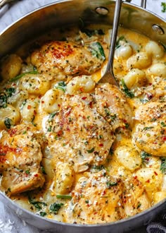 a skillet filled with chicken, potatoes and spinach