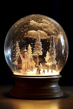 a snow globe with houses and trees in it on top of a wooden table next to a black background