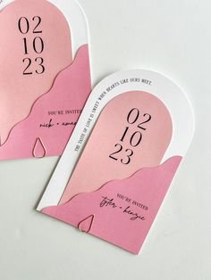 two pink and white wedding tags with numbers on them