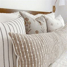 a bed with several pillows on top of it