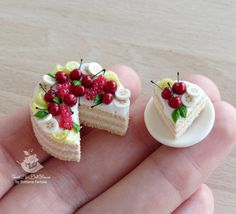 two miniature cakes with cherries on them are being held