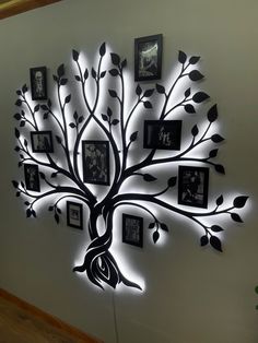 a tree with many pictures hanging on it's sides and lights around the branches