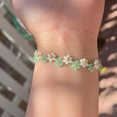 a person wearing a bracelet with flowers on it