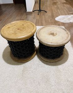 two wooden stools sitting on top of a white carpeted floor next to each other