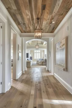 an open floor plan with wood floors and white walls in the hallway leading to another room