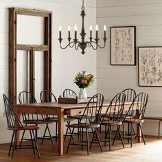 a dining table with six chairs and a vase on it in the middle of a room