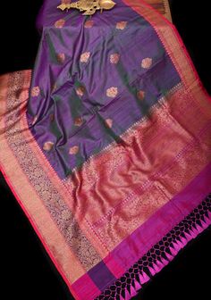 The Purple dual tone Meenakari Antique Zari Butta Pure Banarasi Dupion Silk Saree with two-tone borders is a masterpiece that reflects the timeless beauty of traditional Indian textiles. Crafted from luxurious Banarasi dupion silk, this saree exudes opulence and sophistication. Adorning the saree are exquisite Meenakari Antique Zari Buttas, meticulously woven into the fabric with intricate detailing and precision. The Meenakari work adds a touch of vibrancy and charm to the ensemble, creating a mesmerizing visual display. The saree is further enhanced by its dual-tone borders, which add depth and richness to the overall design. The contrasting borders frame the saree beautifully, adding an element of elegance and grace. Draping this saree is an experience of indulgence and refinement, wher Luxury Banarasi Silk Lehenga With Border, Luxury Banarasi Silk Sets With Meenakari, Luxury Banarasi Silk Pre-draped Saree With Dori Work, Luxury Banarasi Silk Pre-draped Saree With Meenakari, Luxury Saree With Meenakari In Traditional Drape, Luxury Banarasi Silk Traditional Wear With Printed Border, Luxury Pre-draped Banarasi Silk Saree With Gota Work, Luxury Purple Meenakari Saree, Luxury Purple Saree With Meenakari