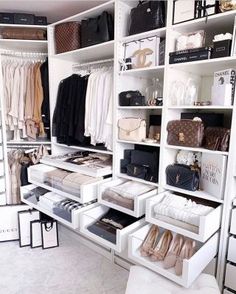 an organized closet with white shelving and lots of purses, handbags and shoes