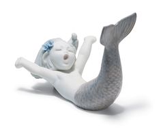 a white mermaid figurine laying on its back with her arms spread out to the side