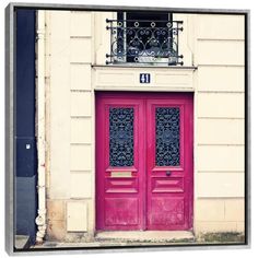 two red doors with wrought iron grills in front of a building