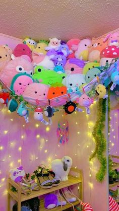 a room filled with lots of stuffed animals hanging from the ceiling and decorations on the wall