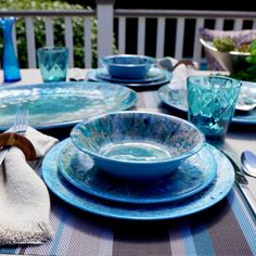 the table is set with blue dishes and silverware