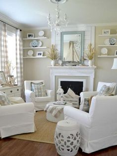 a living room filled with furniture and a fire place under a chandelier in front of a window