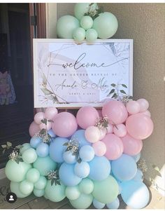 there is a sign that says welcome to the guests at this wedding and balloons are all over the place