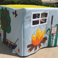 a child's play house with an outdoor fire pit on the front and side