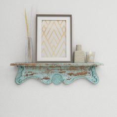 an old shelf with some vases and candles on it next to a framed photograph