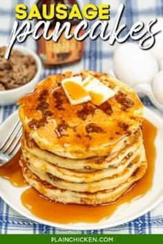 a stack of pancakes sitting on top of a white plate next to eggs and butter