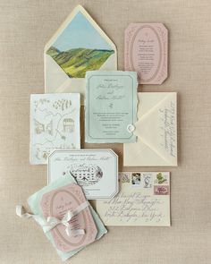 the wedding stationery is laid out on top of each other, including envelopes and cards