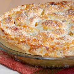 a pie sitting on top of a glass dish covered in powdered sugar and cinnamon