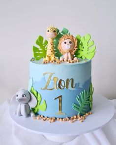 a blue cake decorated with animals and leaves