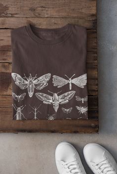 Thanks for stopping by! Moths and Bugs T-shirt Printed on a super soft, cotton tee Dispatched in 5 working days or sooner Unisex Free UK delivery Material: 100% ringspun cotton. Chest (to fit): S  34/36   M  38   L  40/42   XL  44/46   XXL  48/50 ECO-FRIENDLY Each garment is made to order, reducing extra material and energy that would be otherwise wasted We use DTG printing process which is easier on the environment than screen-printing Our ink is bright and also eco-friendly. Do not tumble dry Fairycore Shirt, Climbing Gifts, Black Balloon, Dark Academia Clothing, Trad Goth, Grunge Clothing, Cottagecore Shirt, Grunge Fairycore, Shirt Company