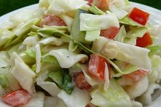 a salad with lettuce, tomatoes and other vegetables in it on a white plate