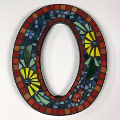 a colorful circle shaped mirror hanging on the wall