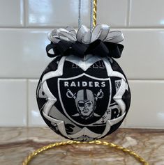 a oakland football ornament hanging on a kitchen counter with tiles in the background