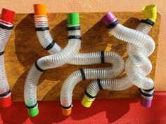 several plastic pipes are lined up on a wooden board