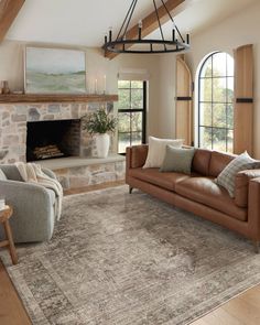 a living room filled with furniture and a fire place in the middle of an open floor plan