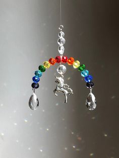 a wind chime hanging from a wire with beads and charms on it's side