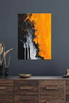 an abstract painting hangs on the wall above a dresser