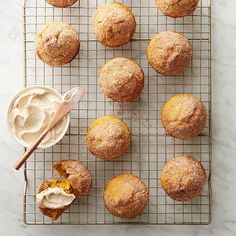 muffins cooling on a wire rack with icing and a spoon next to them