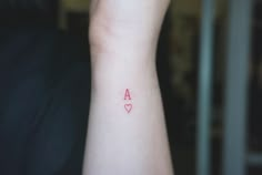 a person with a small tattoo on their arm that has a heart in the middle