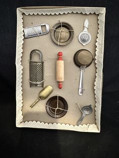 an assortment of kitchen utensils are displayed in a shadow box on a black background