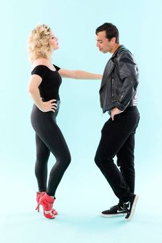 a man standing next to a woman in tight pants