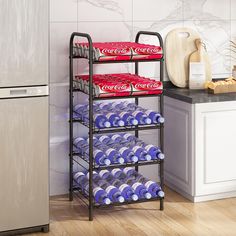 a metal shelf filled with soda cans next to a refrigerator and counter top covered in cookies