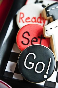 decorated cookies in the shape of crosses on a checkered tray with words reading ready set go