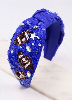 a blue headband with sequins and stars on it, sitting on a white surface