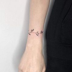 a woman's hand with a small tattoo on it, holding onto the wrist