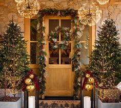 christmas wreaths and lights decorate the front door of a house