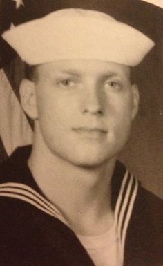 an old photo of a man in a sailor's uniform with the american flag behind him