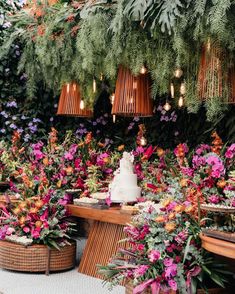 a table topped with lots of different types of flowers next to baskets filled with plants