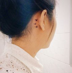 a woman with a small tattoo on her left ear