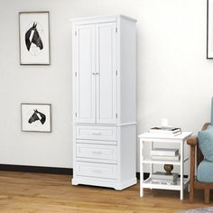 a white armoire and chair in a room with pictures on the wall behind it