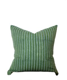 a green and white striped pillow on a white background