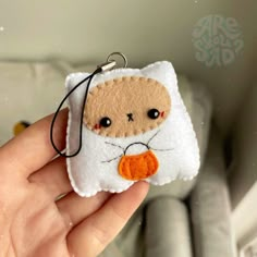 a hand holding a keychain with a stuffed animal on it