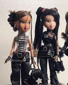 three dolls dressed in black and white outfits