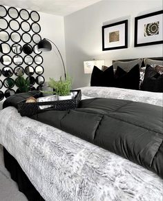 a bedroom with black and white decor on the walls, bedding, and pillows